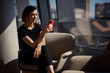 © Westend61 - Young businesswoman using smart phone sitting on armchair at office