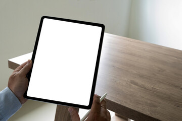 Poster - a businessman holds a mockup. ipad digital tablet with blank screen mockup replaces your design mock