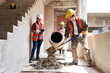 © Robert Kneschke - Young multiethnic male and female masons mixing cement by supervisor at incomplete housing development