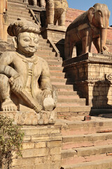 Wall Mural - Two rows of big stone statues, sculptures, guardians line up next to the stairs leading up to the Nyatapola Temple, Bhaktapur, Nepal