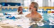 © peopleimages.com - Dumbbell, group and mature man in swimming pool for exercise, healthy body and strong muscle. Aqua therapy, water and aerobics class for fitness, physiotherapy or rehabilitation of senior person