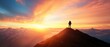© narak0rn - Silhouette of a hiker on a mountain peak at sunrise.