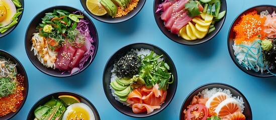 Wall Mural - Various poke bowl arrangements displayed from above on a blue background for copy space image