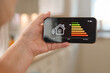 © Monkey Business - Smart Home Energy Management Displayed on a Smartphone in a Modern Kitchen Environment