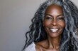© julija - elegant mature black woman with long gray hair radiant skin confident smile beauty and skincare concept soft flattering lighting