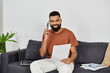 © LIGHTFIELD STUDIOS - Happy man chatting on the phone while going through important documents.