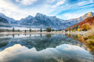 Wall Mural - captivating autumn scene of foggy and sunny morning on almsee lake.