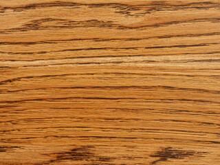 Close-up of a wooden surface with distinct texture. Natural patterns and warm wood tones create an attractive backdrop for a variety of design