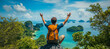 © Marek - Un joven con una mochila sentado en la cima de una montaña y disfrutando de la vista de una isla de playa tropical en Tailandia, con los brazos en alto como si estuviera celebrando el éxito o la liber