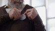 © Synthex🇺🇦 - Senior male voter putting a vote button on his chest after fulfilling civic duty