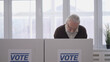 © Synthex🇺🇦 - Elderly man voting at a polling station, conscious citizen electing the president