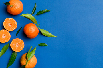 Wall Mural - Many fresh ripe mandarin with green leaves on colored background, top view, space for text