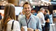© Dao - Happy male entrepreneur discussing with delegates while having coffee at convention center