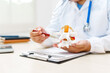 © Phushutter - A doctor uses an anatomical lumbar disc herniation model to explain spinal health, treatment options, and pain management to a patient in a medical clinic.