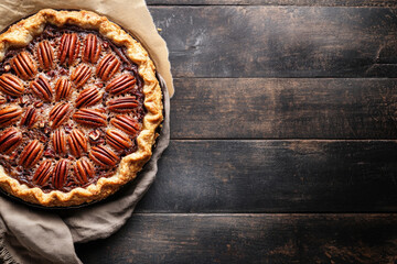 Wall Mural - Homemade autumn pecan pie on a rustic background, top view with copy space.