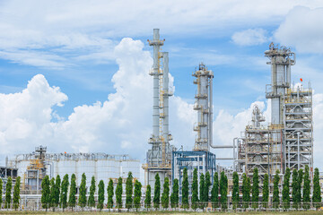 Wall Mural - Green petrochemical Industrial, Refinery plant with tree blue sky. Green industry eco production for sustainable saving environmental friendly low carbon footprint concept.