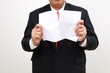 © ArvStd - Businessman tearing blank paper apart on white background. Close up