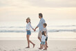 © Frank Coop/peopleimages.com - Beach, vacation and holding hands with family, bonding and happy adventure by ocean on sky. Mom, father and children explore with parents in Miami shore for holiday walk, trip and summer travel