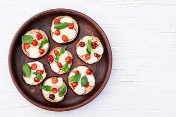 Wall Mural - Italian mini pizza . Aubergine (eggplant ) with mozzarella cheese and basil . On rustic background