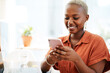 © MollerFinest/peopleimages.com - Typing, business and black woman in office with mobile for communication, texting or social network. Digital, media agency and employee with smile for online, checking web post or browsing internet