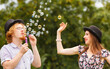 © Voyagerix - Couple blowing soap bubbles, having fun
