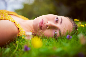 Canvas Print - Woman, portrait and relax on grass outdoor, travel and countryside nature for peace or calm. Female person, rest and field or meadow for wellness, spring garden and flowers in park on holiday trip