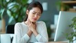 © Stone Story - Woman experiencing throat pain sitting at a desk in an office setting, indicative of health issues like sore throat or stress.