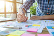 © Dzmitry - Creative Business Planning Session in a Bright Office With Detailed Charts and Colorful Post-Its During Afternoon Hours
