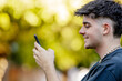 © carballo - young man or teenager on the street with mobile phone