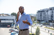 © zinkevych - Confident man wearing blue shirt talking on mobile phone having business conversation