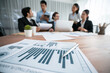 © InfiniteFlow - Piles of analyzed financial data dashboard on meeting table with background of business people analyzing data analysis market trend indication for strategic marketing investment plan. Habiliment