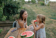© Anna Artemenko/Stocksy - woman with little daughter eating watermelon