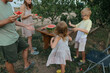 © Anna Artemenko/Stocksy - family eating watermelon in the garden near the house