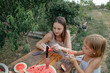 © Anna Artemenko/Stocksy - woman with little daughter eating watermelon