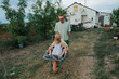 © Anna Artemenko/Stocksy - father rides children in a wheelbarrow