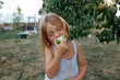 © Anna Artemenko/Stocksy - girl eating pear in the garden