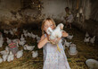 © Anna Artemenko/Stocksy - portrait of a girl with a chicken in her hands