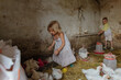 © Anna Artemenko/Stocksy - children on the farm catch chickens in the barn
