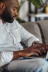 Poster - person sitting on a couch with a laptop, ideal for articles about remote work or technology