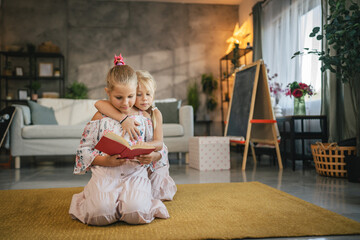 older friend sister help her young friend sister to read a book