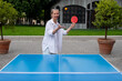 © Amor Burakova/Stocksy - Woman pitchs a ball in table tennis play
