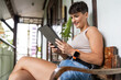 © Alvaro Lavin/Stocksy - Happy freelancer woman using tablet and sitting on a terrace