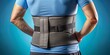 © Caitlin - Isolated on a bright blue background, a lumbar support brace is wrapped around the lower back, highlighting orthopedic relief for muscle strain and lower back problems.