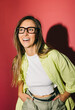 © VICTOR TORRES/Stocksy - Happy woman in glasses, green shirt, and white top