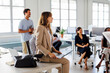 © BONNINSTUDIO/Stocksy - Businesswoman holding laptop listening during office meeting