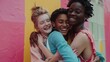 © Drew - Diverse group of friends hugging against colorful wall