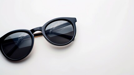 Round black sunglasses on a white surface