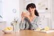 © New Africa - Woman with glass of lemon water indoors