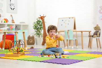 Poster - Cute little boy playing with math game Fishing for Numbers on puzzle mat in kindergarten