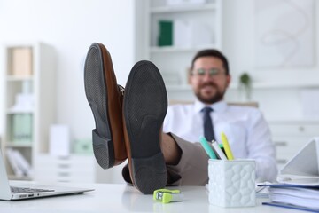 Wall Mural - Businessman holding legs on table in office, selective focus. Break time